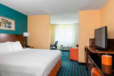 a hotel room with a bed and a flat screen tv at Fairfield Inn & Suites Springfield in Springfield