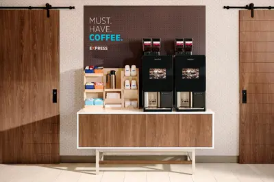 a coffee shop with a counter with a coffee maker on it at Holiday Inn Express & Suites Columbus East - Reynoldsburg by IHG in Reynoldsburg