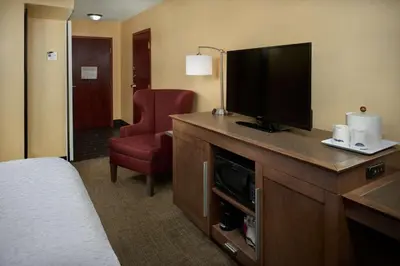 a hotel room with a bed and a flat screen tv at Hampton Inn Shelbyville in Shelbyville