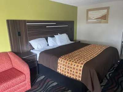 a hotel room with a bed and a chair at Blue Stone Inn in Washington Court House