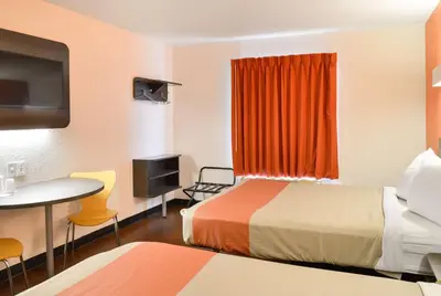 a small hotel room with two beds and a table at Motel 6-Toledo, OH in Maumee