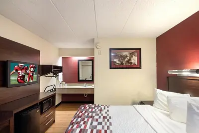 a hotel room with a bed and a sink at Red Roof Inn Cincinnati East - Beechmont in Cherry Grove