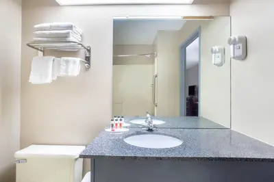 a bathroom with a sink and a mirror at Super 8 by Wyndham Harrison OH in Harrison