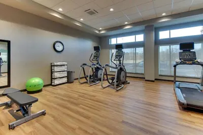 a gym with exercise bikes and a clock in a room at Drury Inn & Suites Columbus Polaris in Columbus