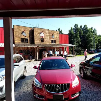 a red car parked in front of a building at The Hampton - An Amish Built Deluxe Log Cabin in Genoa