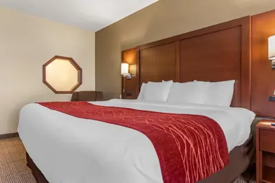 a hotel room with a large bed with a red blanket at Comfort Inn & Suites Streetsboro - Kent in Streetsboro