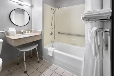 a bathroom with a sink and a tub and a mirror at Super 8 by Wyndham St. Clairsville OH/Wheeling WV Area in Saint Clairsville