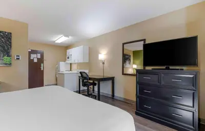 a hotel room with a bed and a flat screen tv at Extended Stay America Suites - Columbus - Dublin in Dublin
