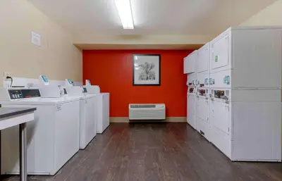 a room with white washing machines and an orange wall at Extended Stay America Suites - Columbus - Dublin in Dublin