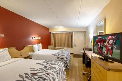 a hotel room with two beds and a flat screen tv at Red Roof Inn Canton in Canton