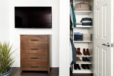 a closet with a television and a dresser with shoes at InTown Suites Extended Stay Cincinnati OH - Colerain in Cincinnati