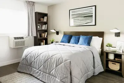 a bedroom with a large bed with blue pillows at InTown Suites Extended Stay Select Dayton OH- Miamisburg in Dayton