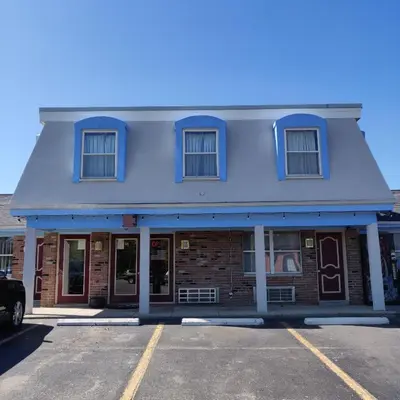 an empty parking lot in front of a blue building at Travel Inn in Delaware