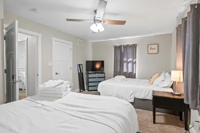 a bedroom with two white beds and a desk at Spacious 6BR Near Ark! Ample Parking, 3 Full Baths in Williamstown
