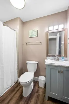 a bathroom with a toilet and a sink and a mirror at Spacious 6BR Near Ark! Ample Parking, 3 Full Baths in Williamstown