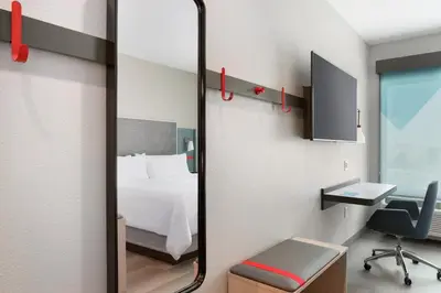 a mirror in a room with a bed and a desk at avid hotels - Columbus Northwest - Hilliard by IHG in Hilliard