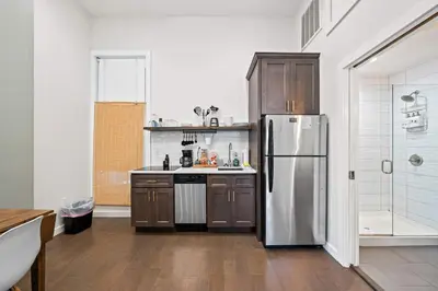 a kitchen with a stainless steel refrigerator and wooden cabinets at 4 Apartments, Downtown, Walk to Cincy Stadiums! in Covington