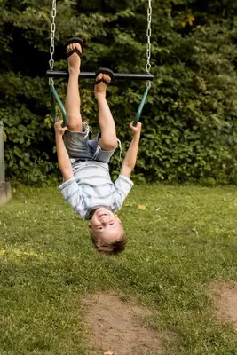 a young child is hanging on a swing at Scotch Pine . Trailside Lodging in Millersburg