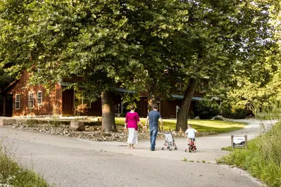 a family walking down a road with their child on aicycle at White Pine . Trailside Lodging in Millersburg