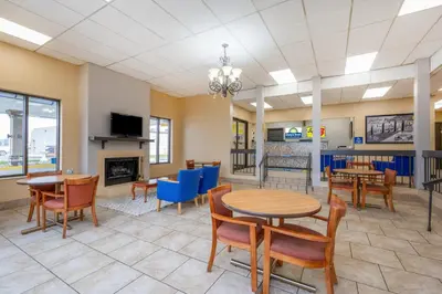 a dining room with tables and chairs and a fireplace at Days Inn by Wyndham Perrysburg Toledo in Perrysburg
