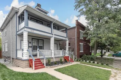 a white and blue house with a brick building at Chic 2BR near DT, 8 min walk to Park&Conservatory in Columbus
