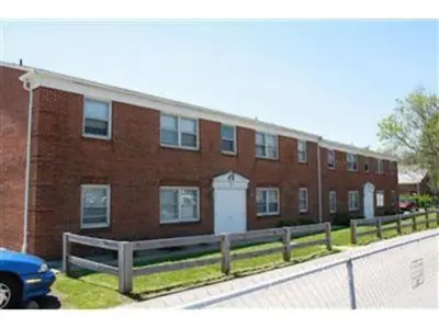 a brick building with a fence in front of it at Cozy Two Bedroom Apartment in the City Center in Trenton