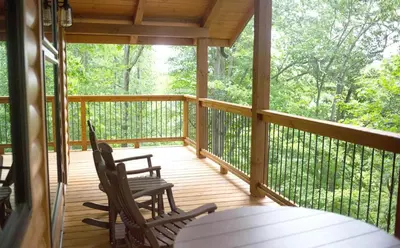 a screened in porch with two chairs and a table at Cricket Hill Treehouse C by Amish Country Lodging in Millersburg