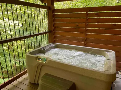 a bath tub sitting on top of a deck at Cricket Hill Treehouse C by Amish Country Lodging in Millersburg