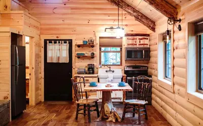 a kitchen with a table and chairs in a cabin at Cricket Hill Treehouse C by Amish Country Lodging in Millersburg