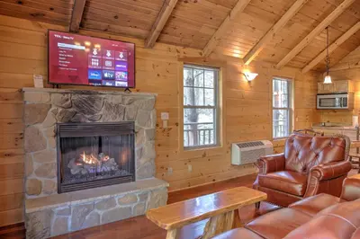 a living room with a fireplace and a tv at Lofty Willows Treehouse by Amish Country Lodging in Millersburg