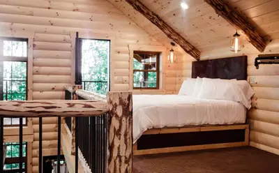 a bedroom with a bed in a log cabin at Treehouse #1 by Amish Country Lodging in Millersburg