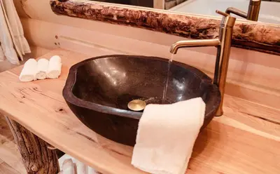 a black sink on a counter in a bathroom at Treehouse #1 by Amish Country Lodging in Millersburg