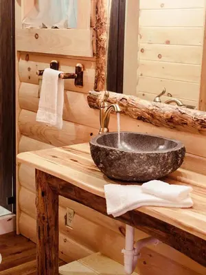 a bathroom with a sink in a log cabin at Treehouse #0 by Amish Country Lodging in Millersburg