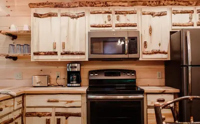 a kitchen with a stove and a microwave at Treehouse #2 by Amish Country Lodging in Millersburg