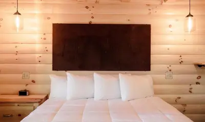 a bedroom with a white bed with a wooden wall at Treehouse #3 by Amish Country Lodging in Millersburg