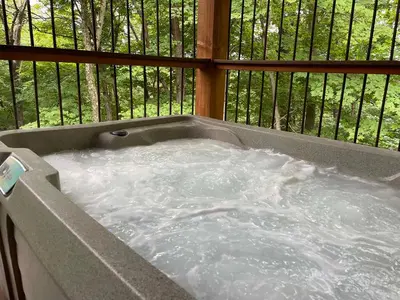 a jacuzzi tub with water in a balcony at Treehouse #8 by Amish Country Lodging in Millersburg