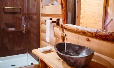a bathroom with a sink in a log cabin at Treehouse #6 by Amish Country Lodging in Millersburg