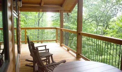 a screened in porch with two chairs and a table at Treehouse #6 by Amish Country Lodging in Millersburg
