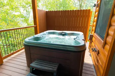 a hot tub sitting on a deck on a porch at Skyview Treehouse by Amish Country Lodging in Millersburg