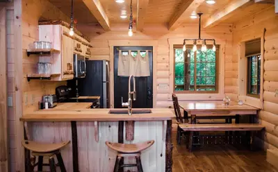 a kitchen with a bar and a table in a cabin at Skyview Treehouse by Amish Country Lodging in Millersburg