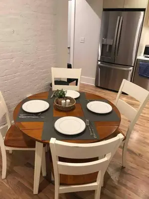 a dining room table with white chairs and a kitchen at Spacious 2 bed 2 bath Downtown OTR condo minutes walk to the Reds Bengals stadium & more! in Cincinnati