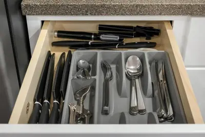 a kitchen sink with utensils in a drawer at Barnwood Suite - Main Street Lodge in Berlin in Berlin