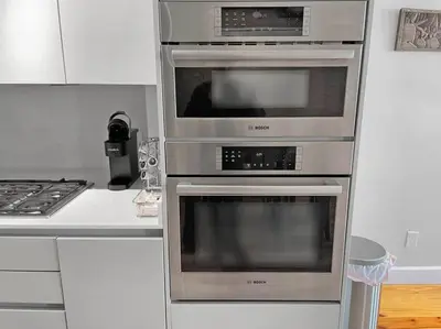 three ovens in a kitchen next to a stove at Luxury 4-Bedroom Retreat in the Heart of Over the Rhine in Cincinnati