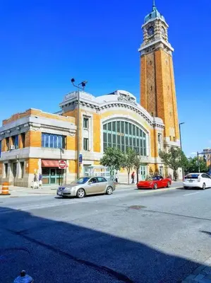 a building with a clock tower with cars parked in front of it at Cozy Cottage 10 mins to DTWN CLE Free Parking in Euclid